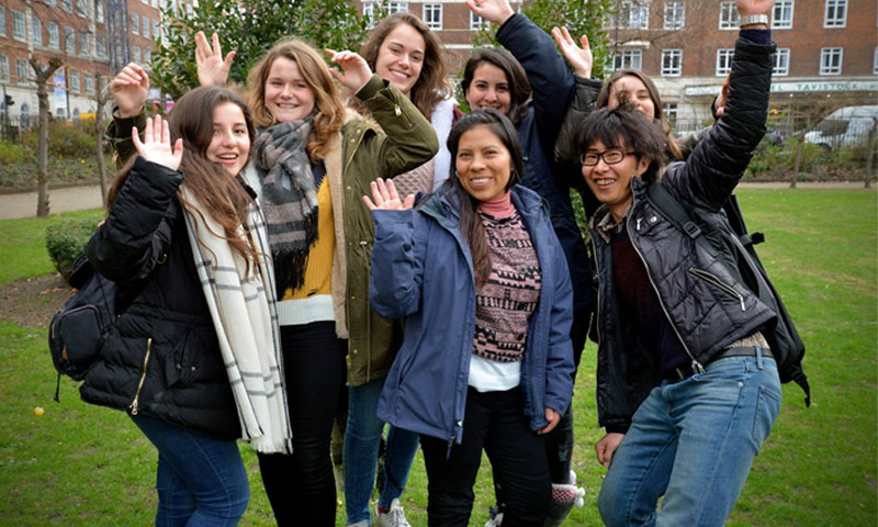 7 people outside with their hands raised in the air