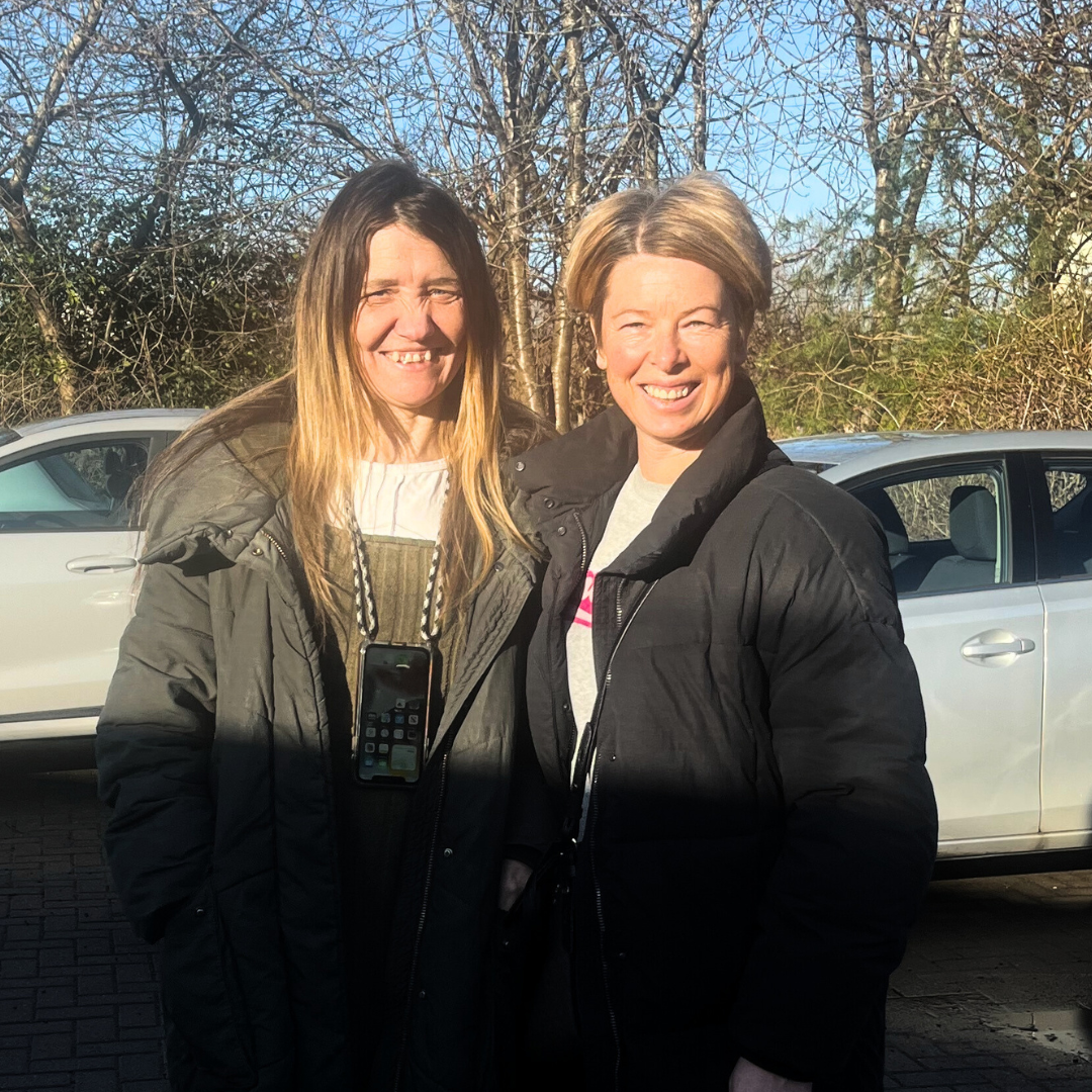 Anna and Andrea, volunteer and service user stood together outside in a car park