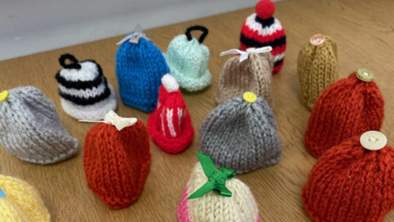 16 knitted smoothie hats featuring a range of different colours, shapes and sizes
