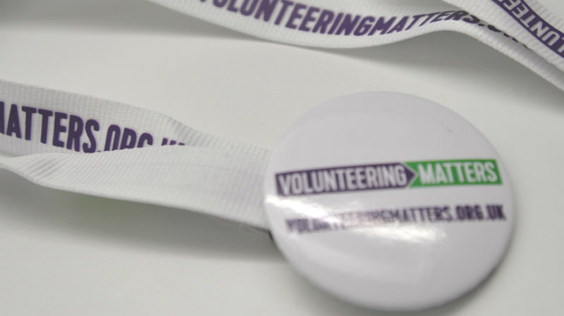 A badge and lanyard with the Volunteering Matters logo on a white background