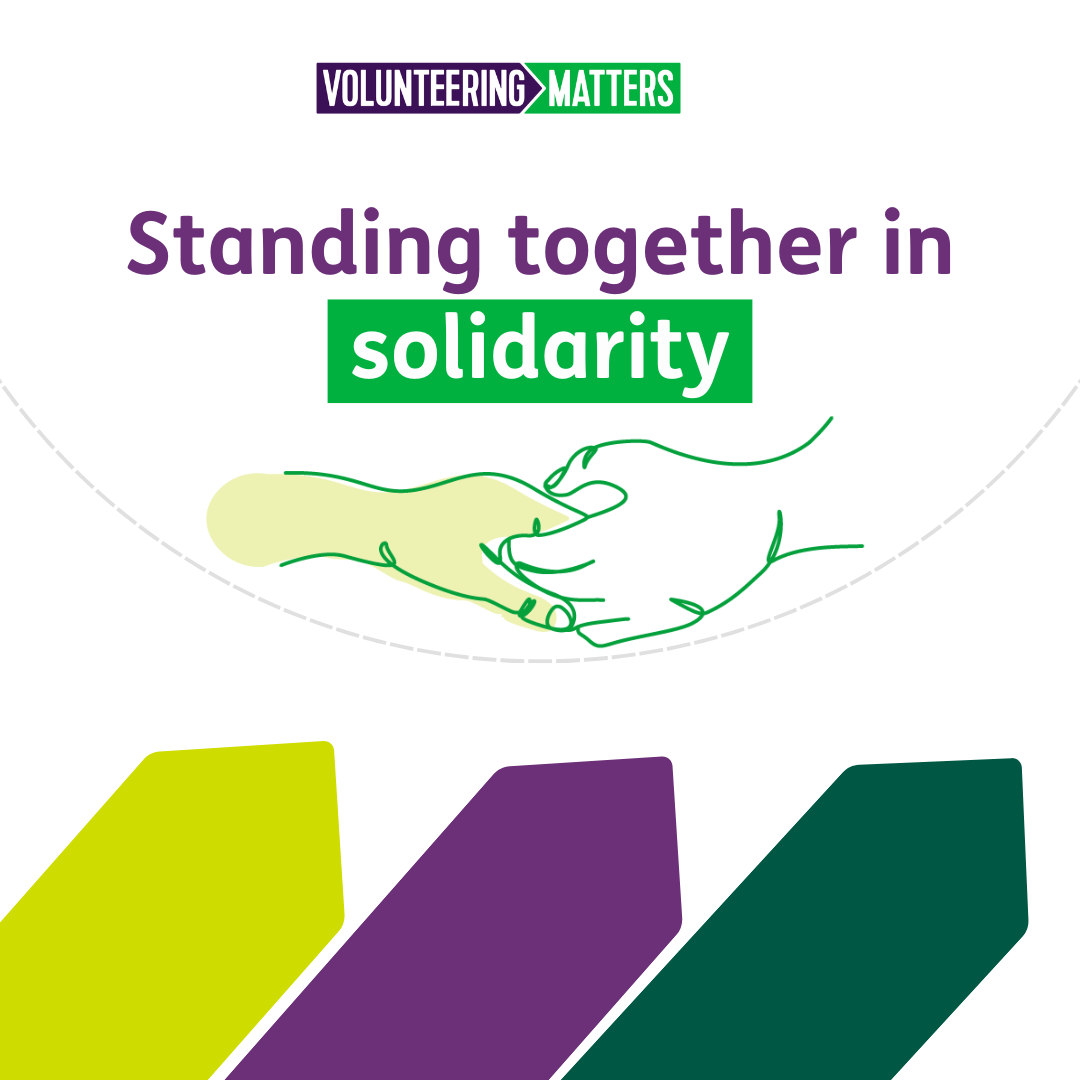 The words standing together in solidarity with a illustration of two hands holding