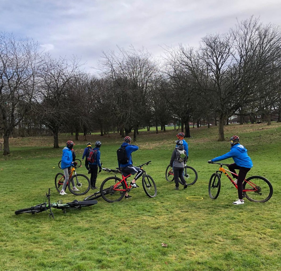 New Scots on bikes with looking into the distance towards trees